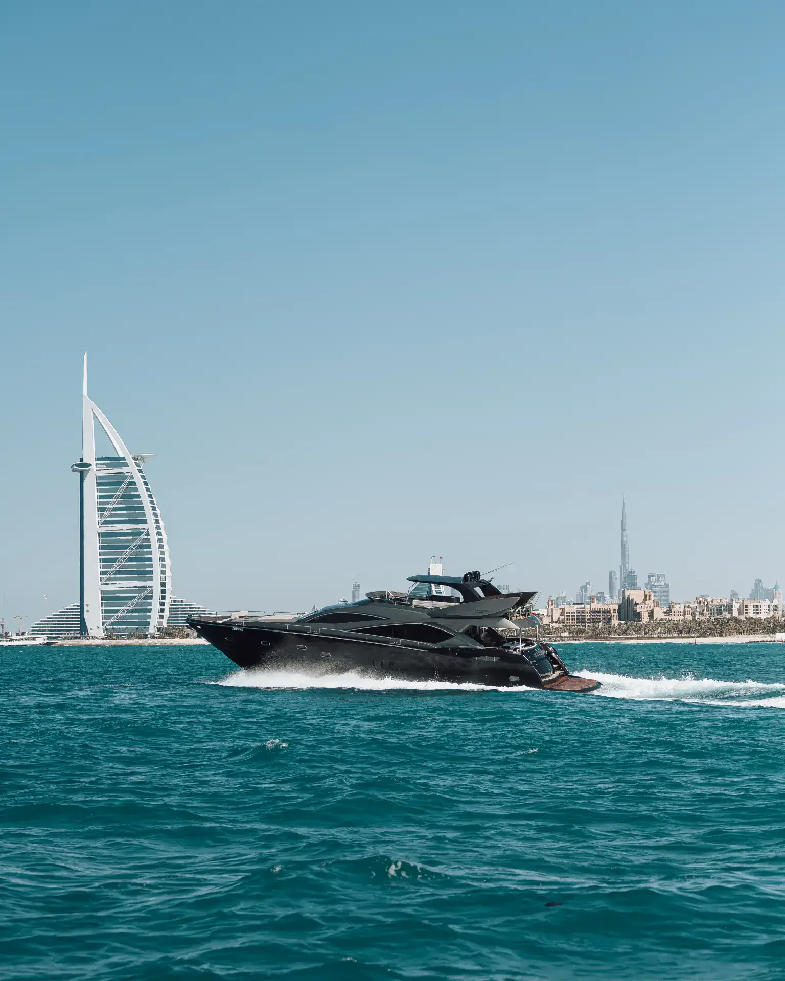 A motor yacht on the water off Dubai with the skyline beyond, the setting for a New Year’s Eve charter