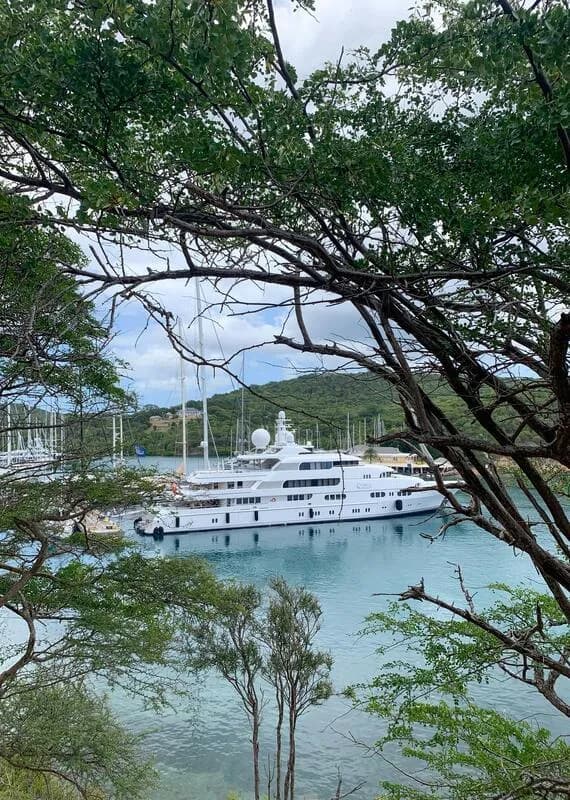 A superyacht moored in a sheltered Caribbean harbour